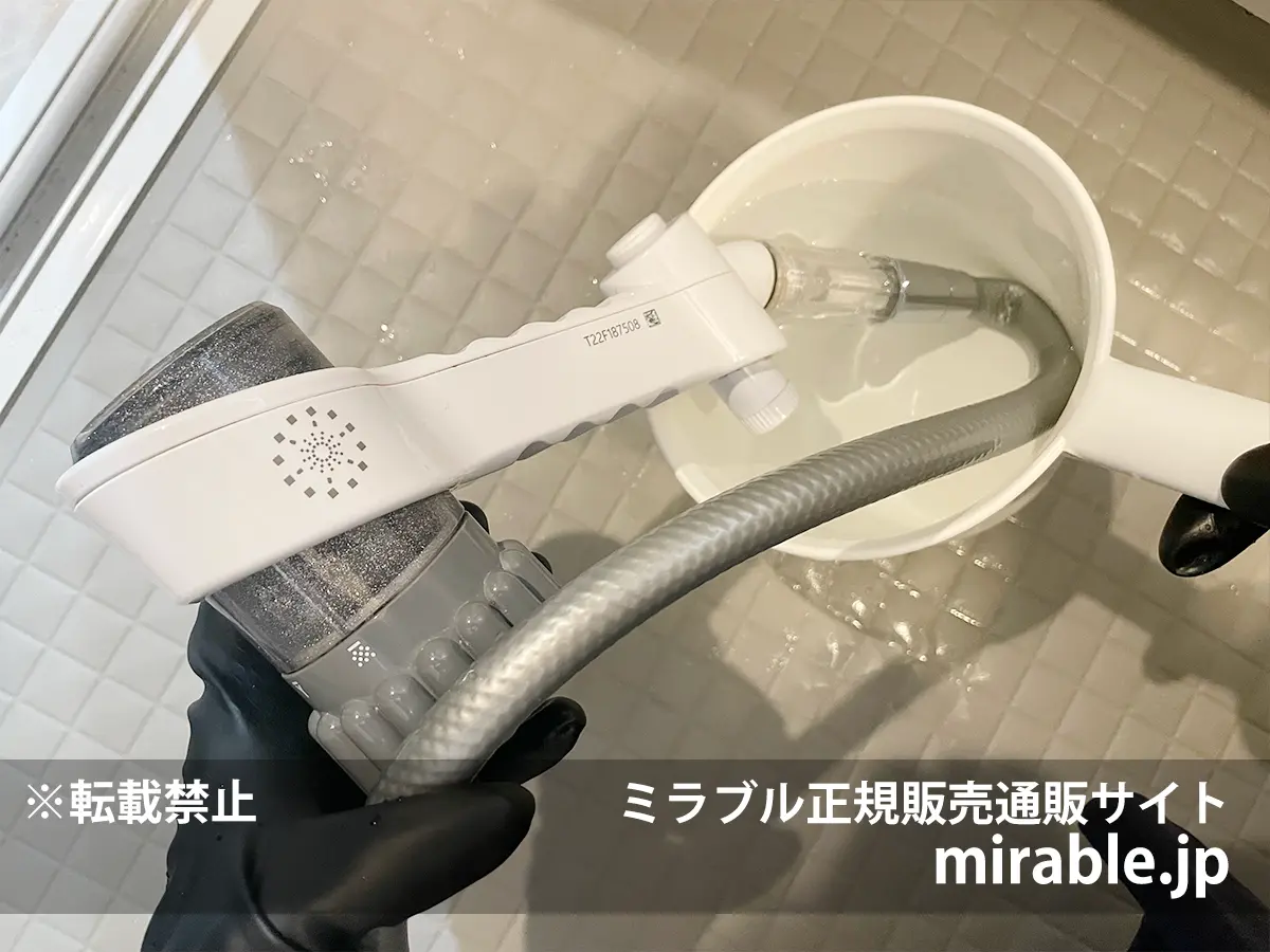 固着したミラブルのトルネードスティックの接続部分をぬるま湯につけて温めている様子